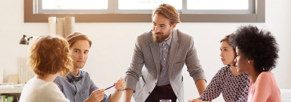 man-leaning-on-table-during-meeting