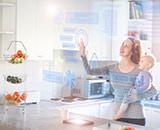 Woman holding a child in a kitchen with a virtual interactive interface