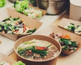 Prepared meals in brown paper serving dishes.