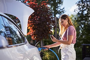 Woman charging a electric vehicle