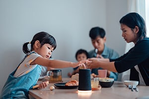 Two children at a dinner table with both parents