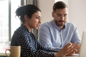 Two people using a laptop