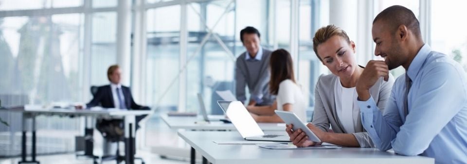 Colleagues looking at tablet in professional setting