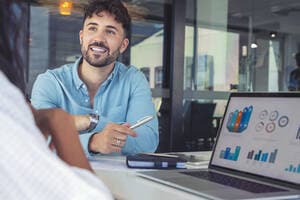 Man showing laptop to colleague