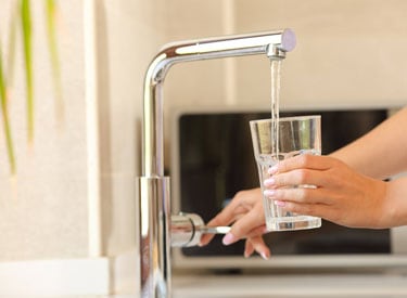 Pouring water from tap into glass