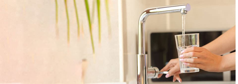 Pouring water from tap into glass