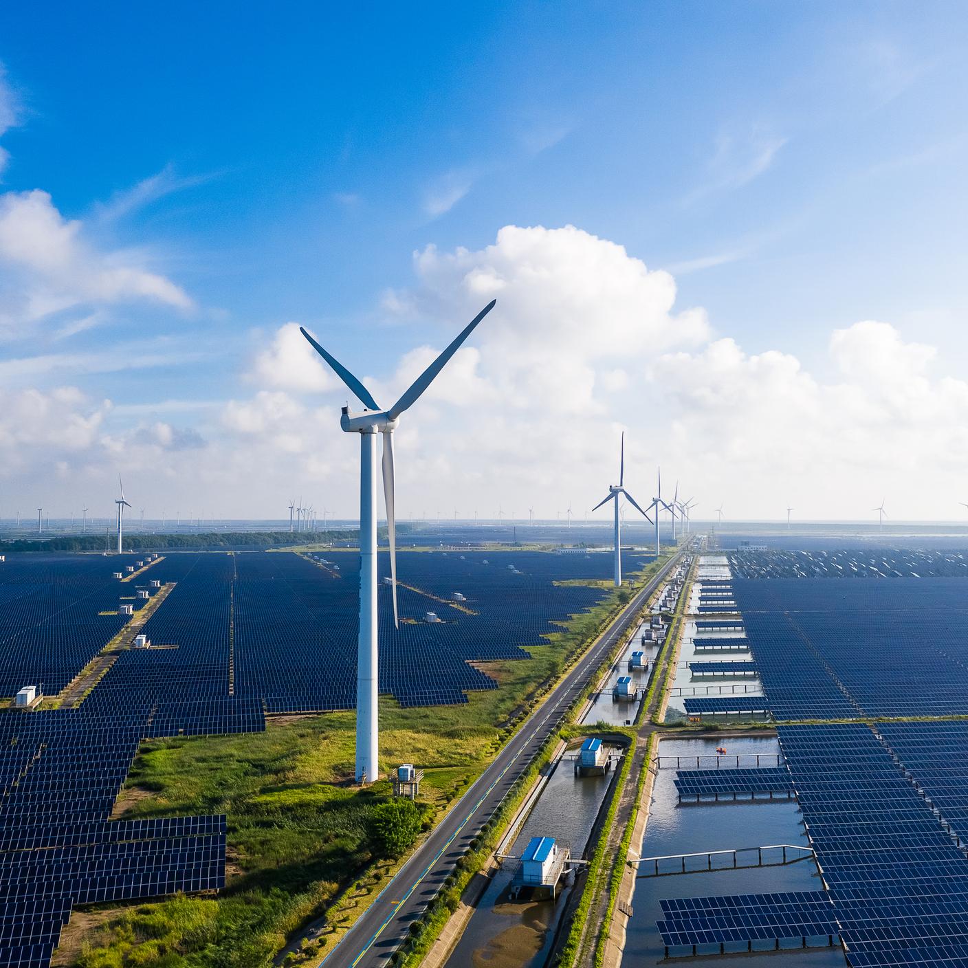 Solar power stations in plain areas, wind turbines in the distance