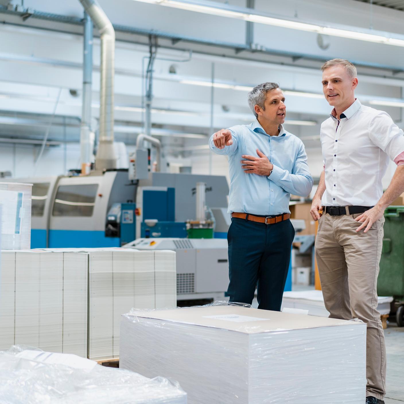 members of a trade association - two colleagues talking in a factory