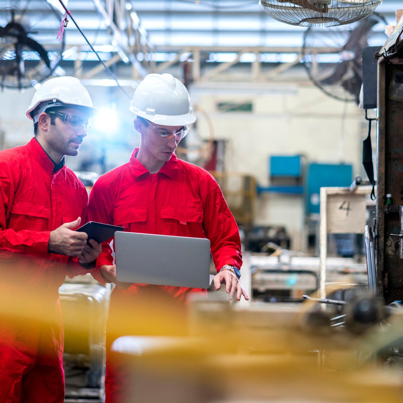 Digital trust - construction workers with laptop in factory