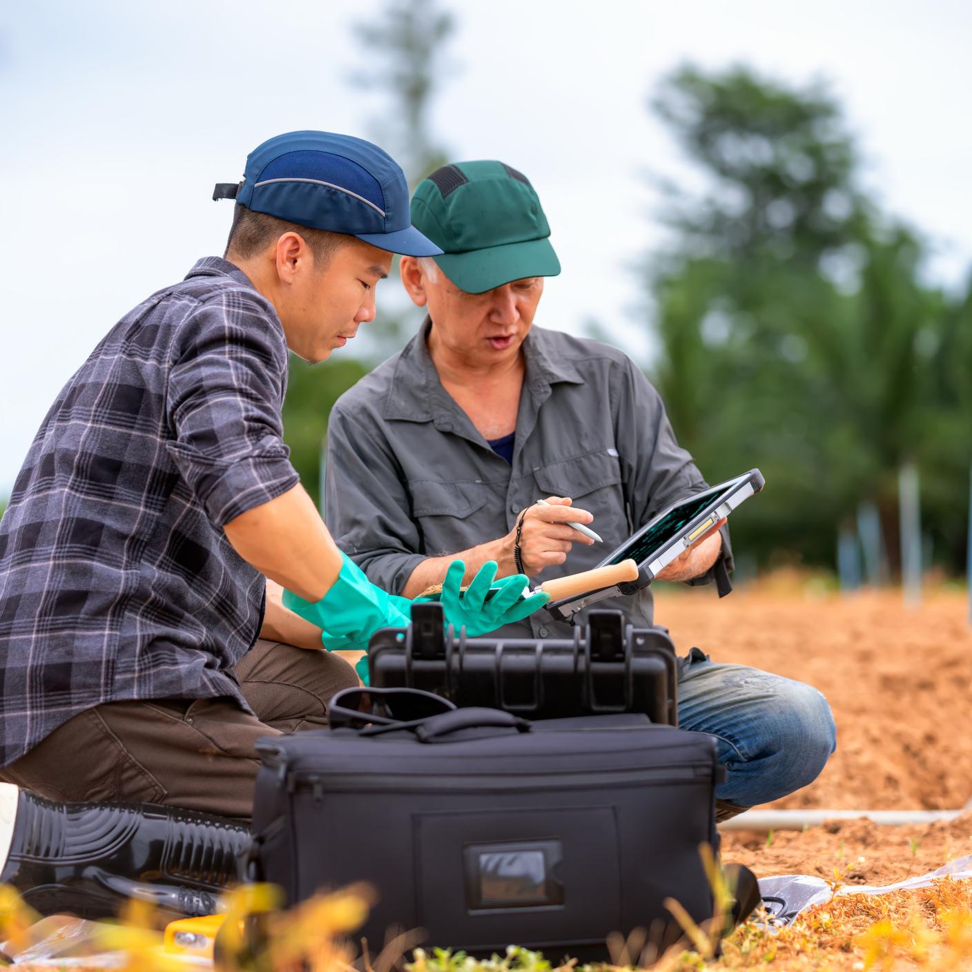 Two soil researchers keep the sample of soil to check the humidity of soil 