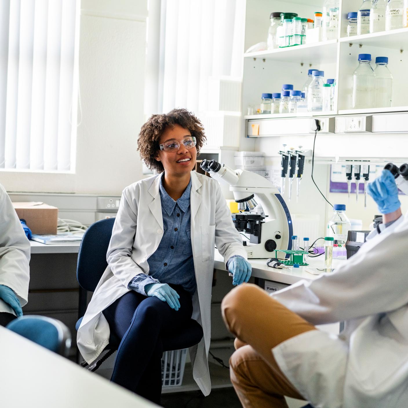  Researchers working together sitting in science laboratory