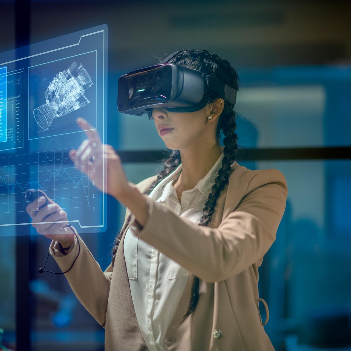 Female engineer wearing a virtual reality headset at work to explore an upcoming mechanical engineering project. She uses her hands to manipulate and explore the finer details.