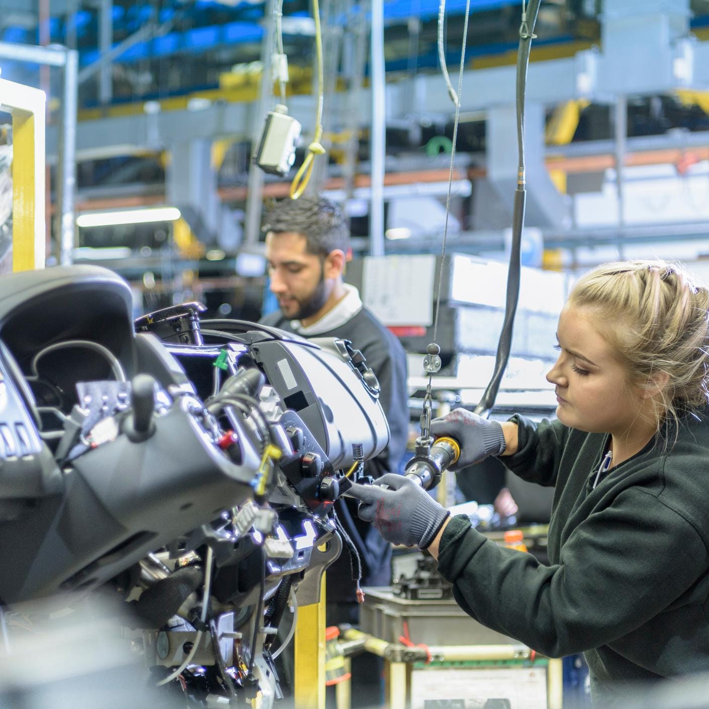 Female apprentice engineer on production line in car factory