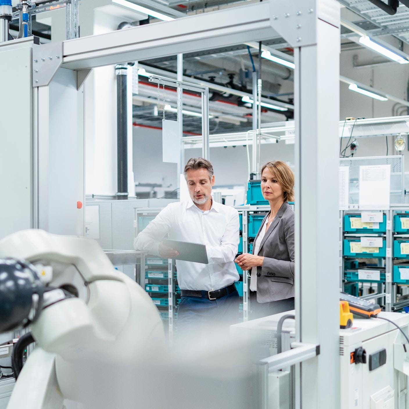 Businesswoman and manwith tablet talking in a modern factory