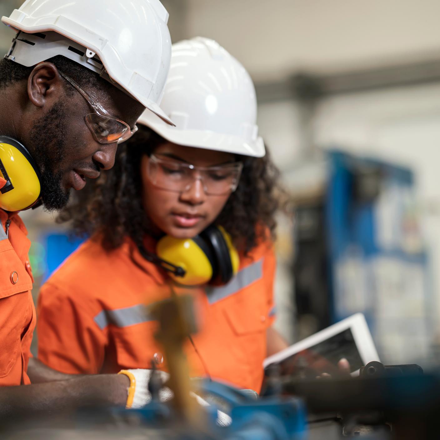 African American Manufacturing Process Engineers Team having discussion on welding jig assembly to tolerance variations in the product parts