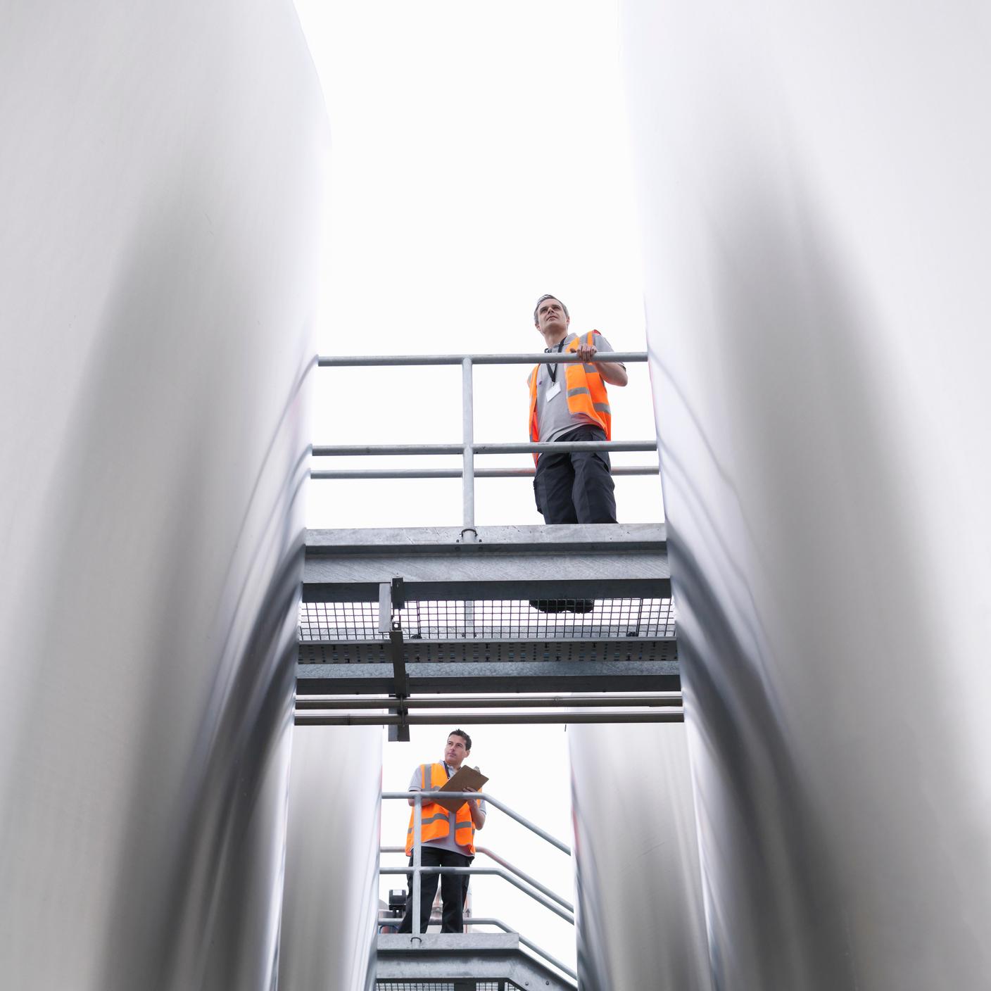 Workers checking tanks in bottling plant