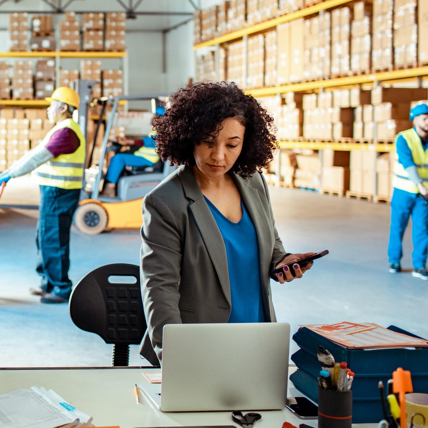 A warehouse manager using a laptop