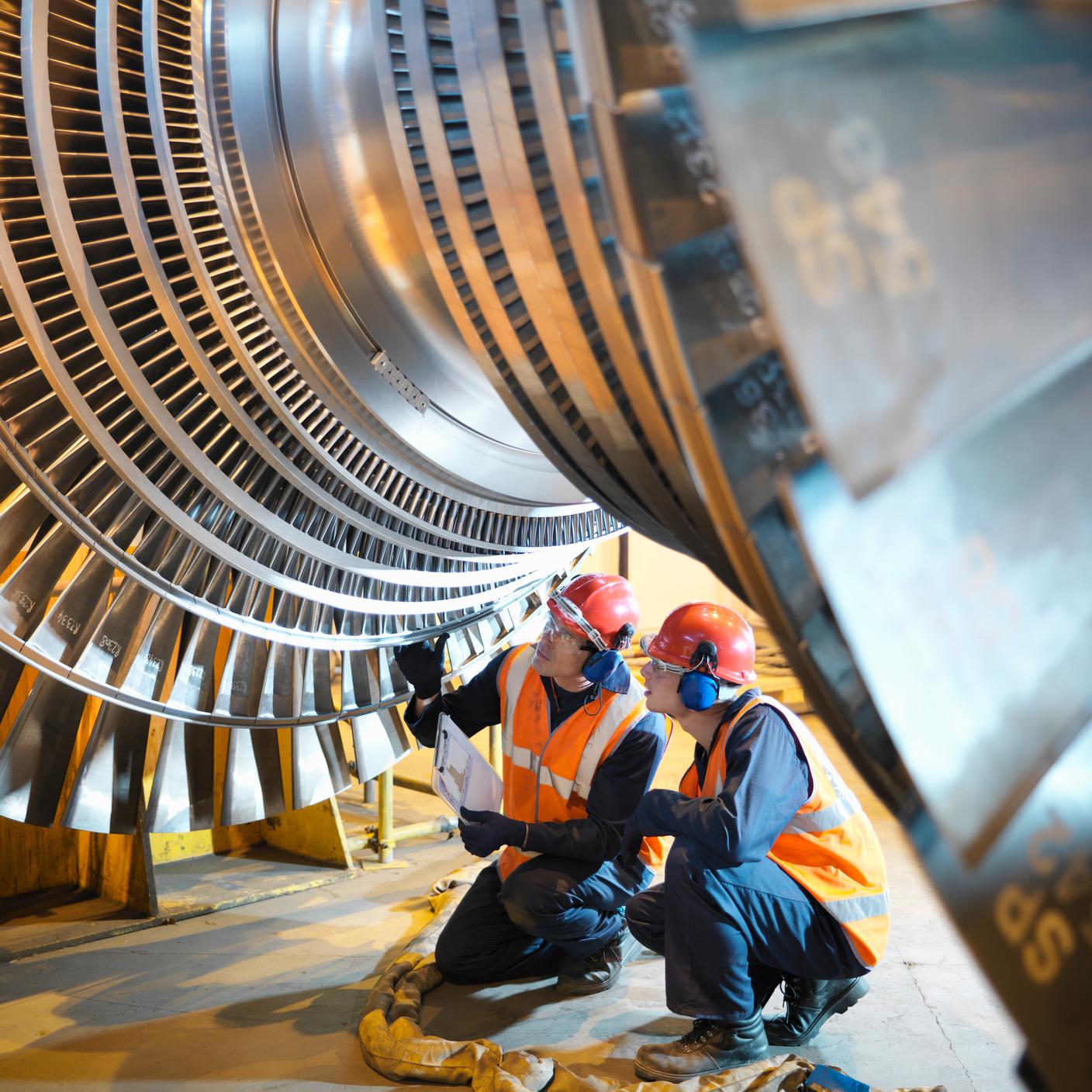 Workers inspect turbine in power station