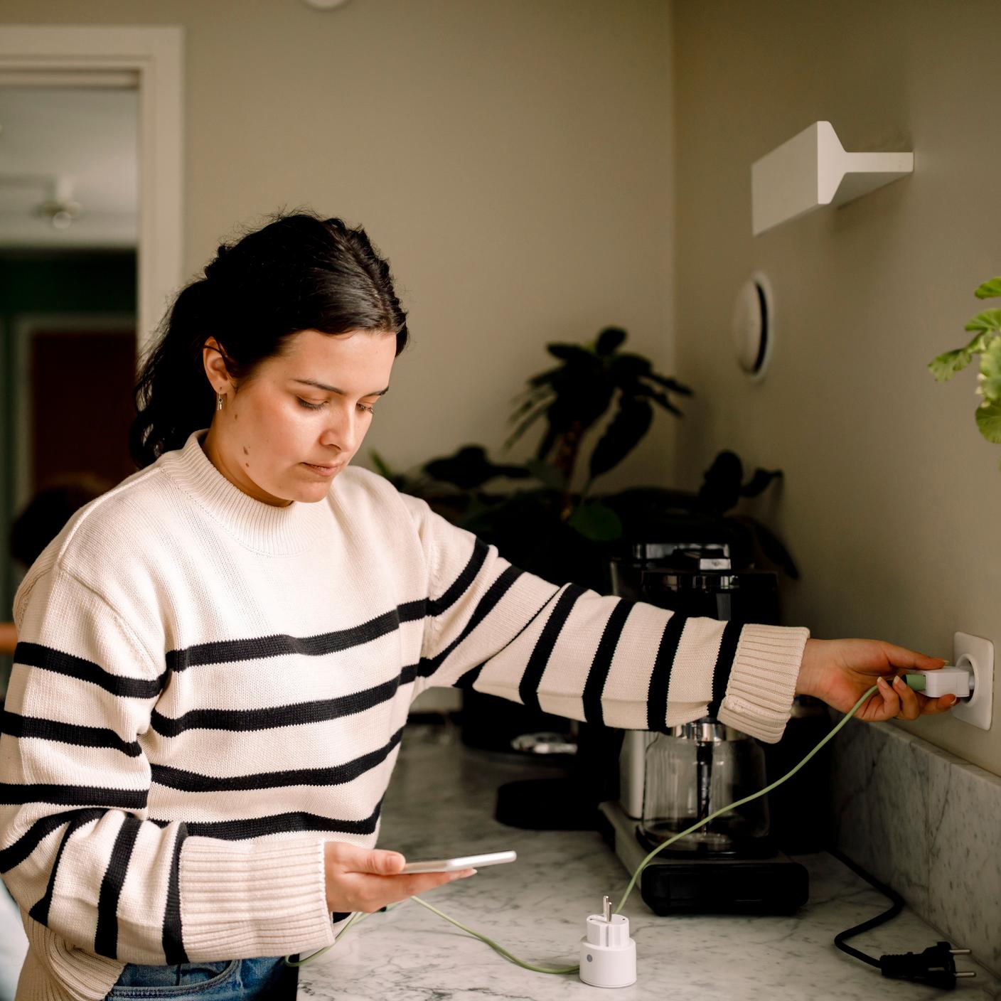 woman charging mobile in kitchen