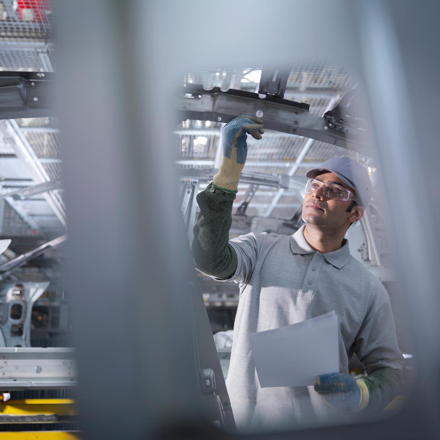 Car plant worker on production line