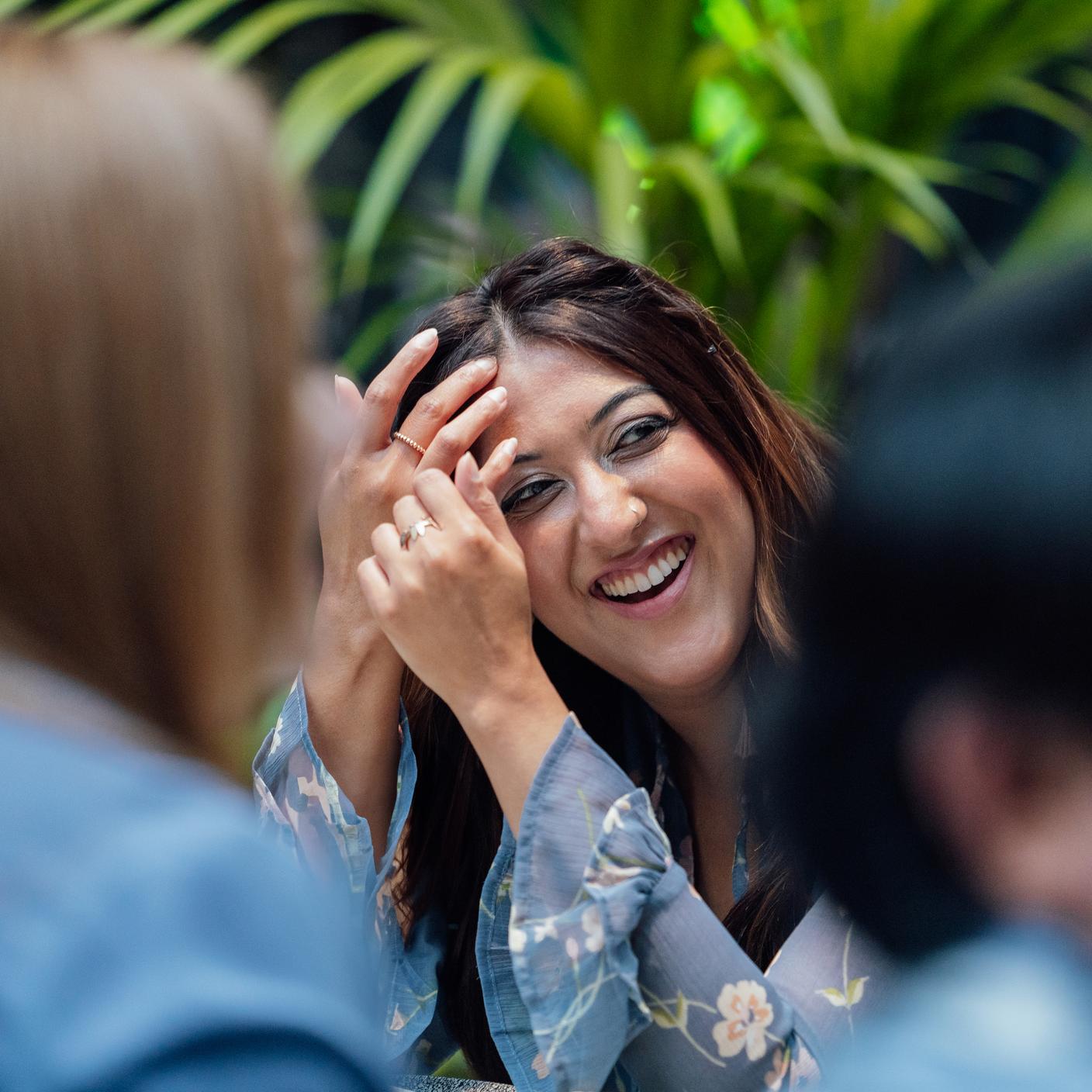 Smiling BSI woman with plant backdrop