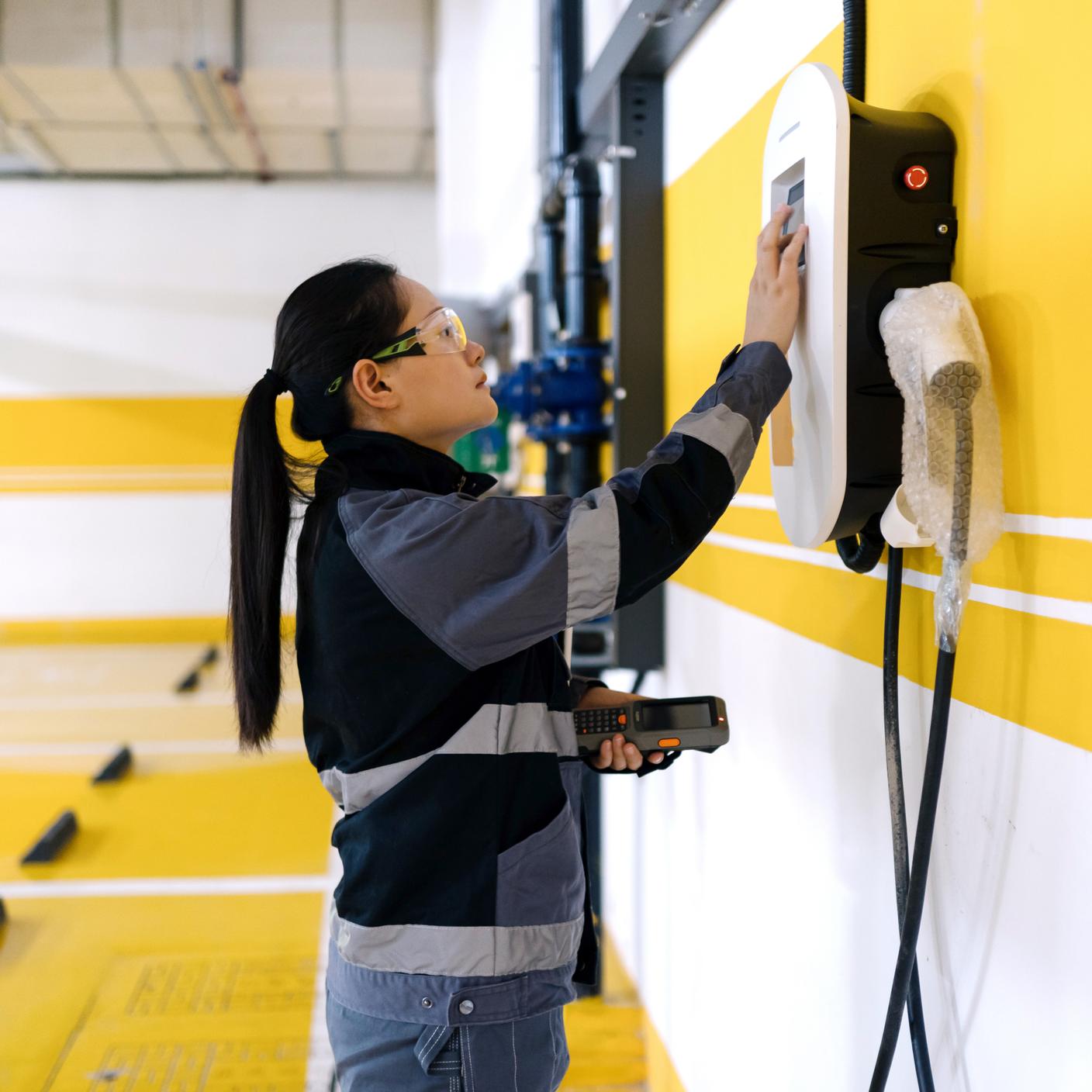 A engineer testing the charging point for an electric vehicle