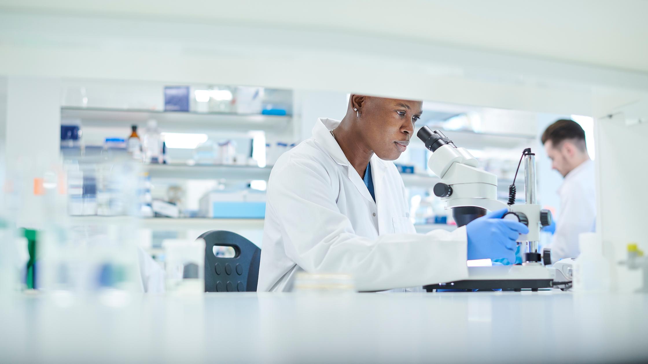 Healthcare - scientist with microscope in lab