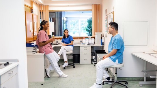 Hospital staff having coffee and talking during break. Male and female healthcare workers having a casual talk during a break in hospital.