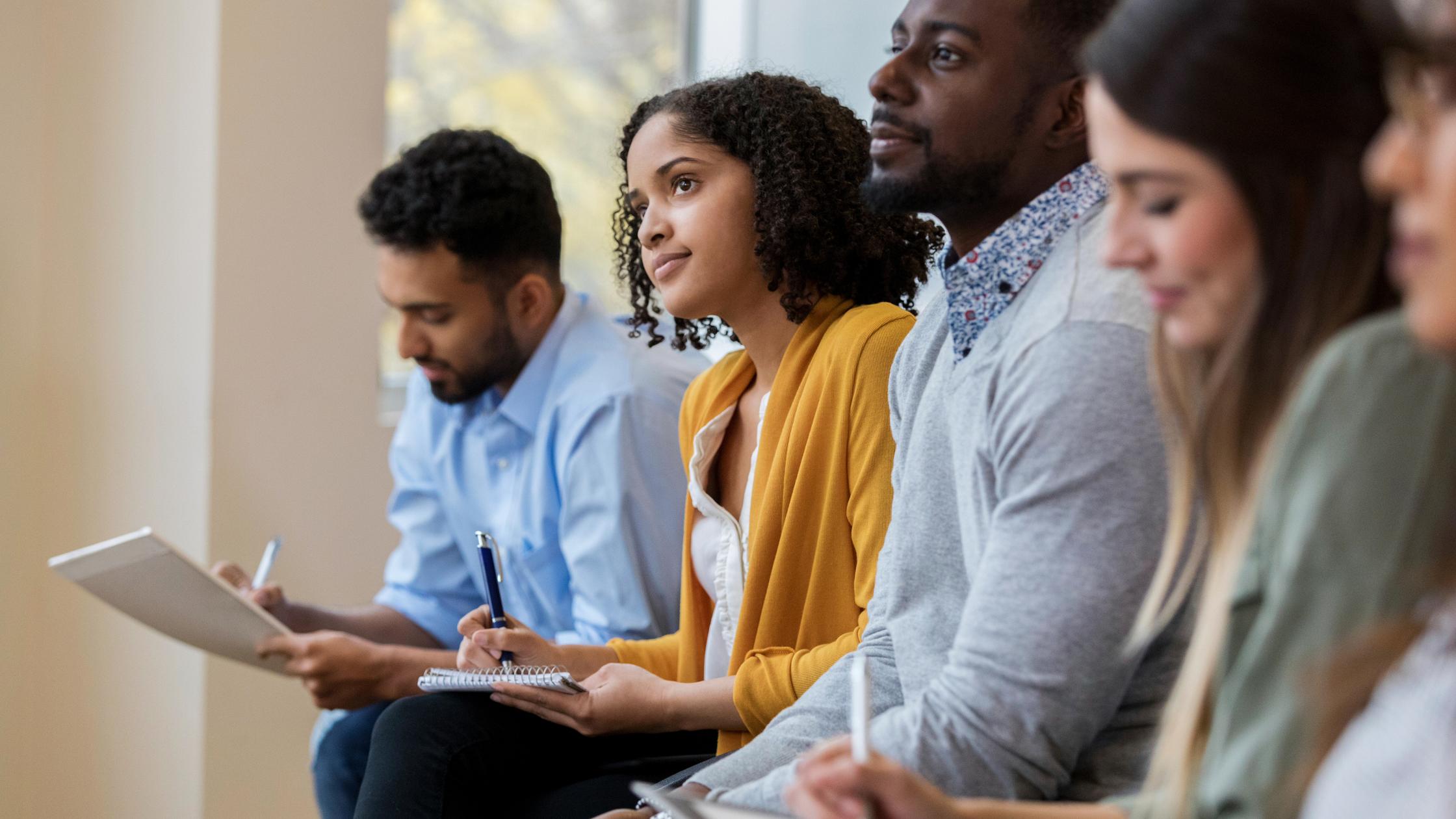 People sitting in a room and taking notes