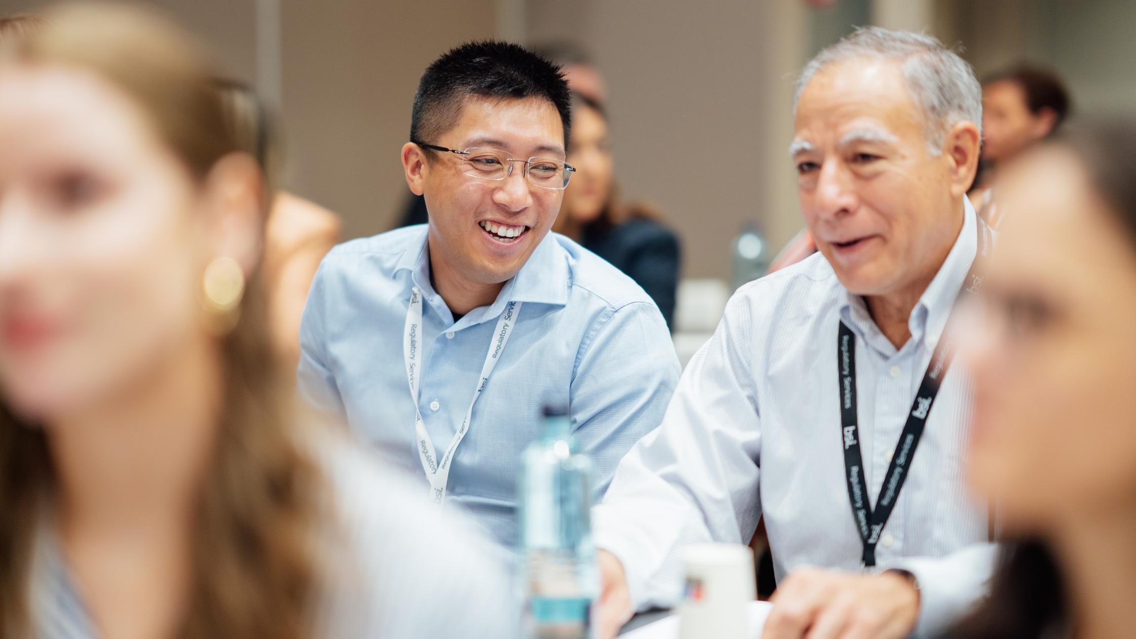 Training course with two people smiling in a large group